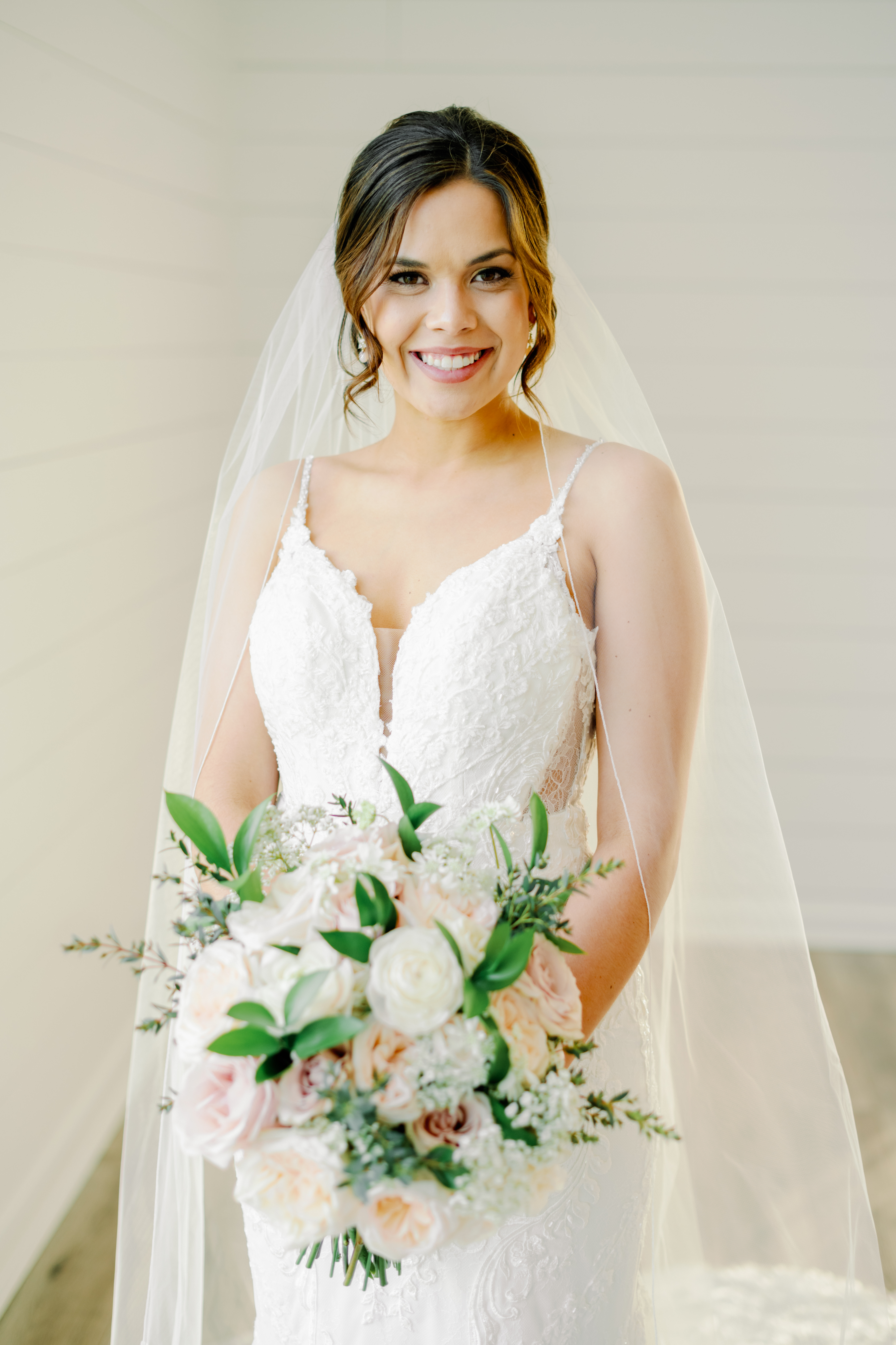 Bride Abbey poses for her bridals with Kati Hewitt Photography in the white chapel at Houston's The Farmhouse Wedding Venue